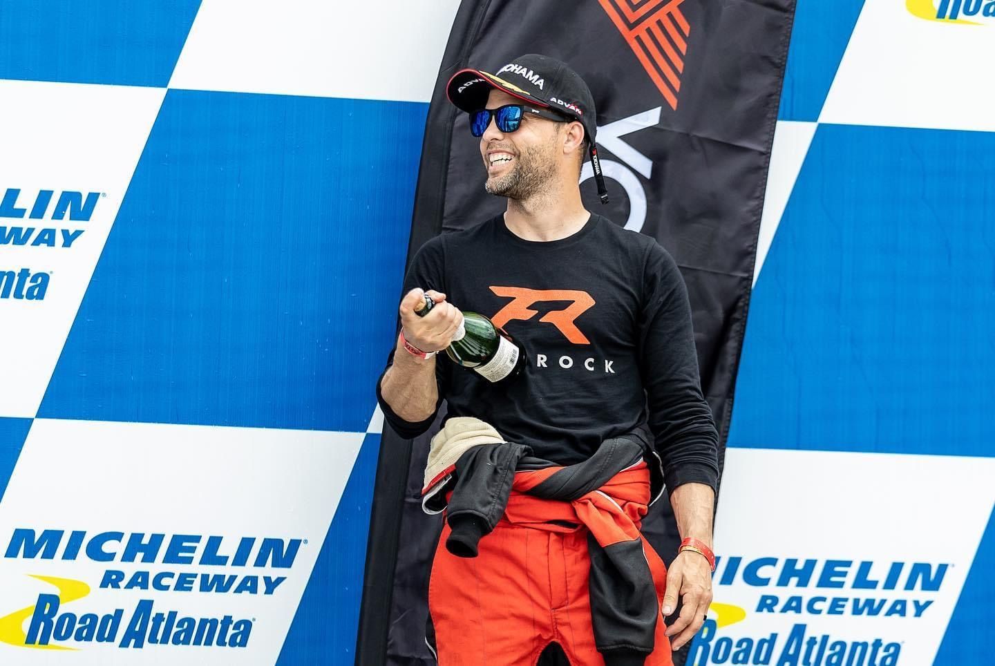 Jason in a Flatrock shirt celebrating on the Road Atlanta podium
