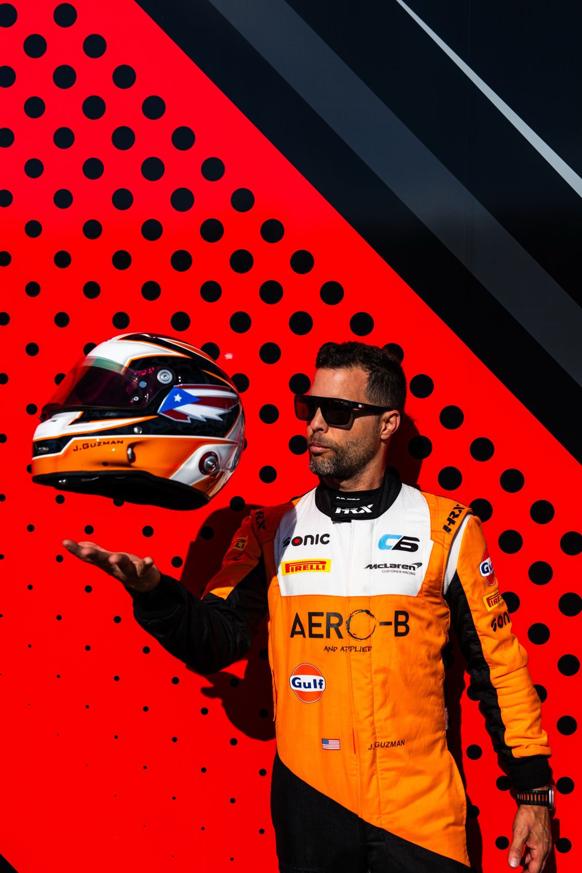 Jason tossing his Puerto Rico-flag helmet in his race suit