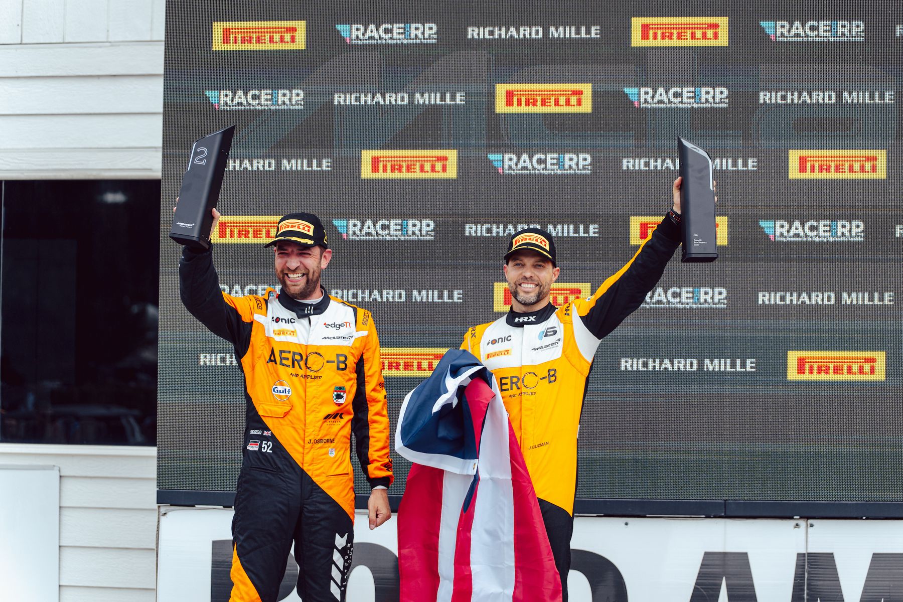 Jason Guzmán holding the Puerto Rican flag on the McLaren Trophy America podium at Road America